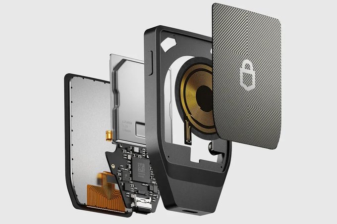 An exploded view of an electronic device showing its internal components, including a circuit board, battery, and speaker with a gray textured cover.