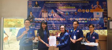 Six individuals in blue shirts pose in front of a Thai-language banner at an IIAT (International Industry Alliance Thailand) regional leaders' meeting, where they are holding documents and certificates as part of a Pi Network merchant consultation and onboarding initiative.