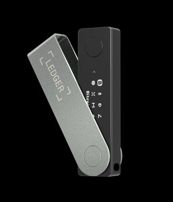 A product photo of a Ledger hardware cryptocurrency wallet with its protective metal cover engraved with '< LEDGER >', displayed against a black background with screen showing Bitcoin and other asset icons.