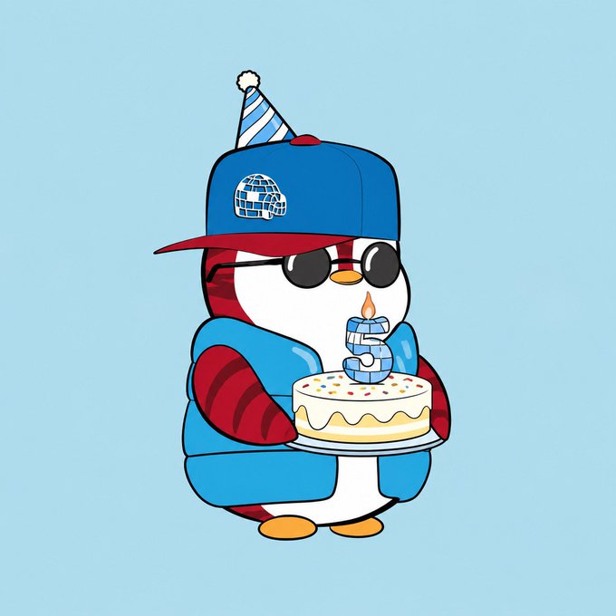 Cartoon penguin mascot wearing a blue and red cap, sunglasses, and a jacket, holding a birthday cake with a candle shaped like the number 5.
