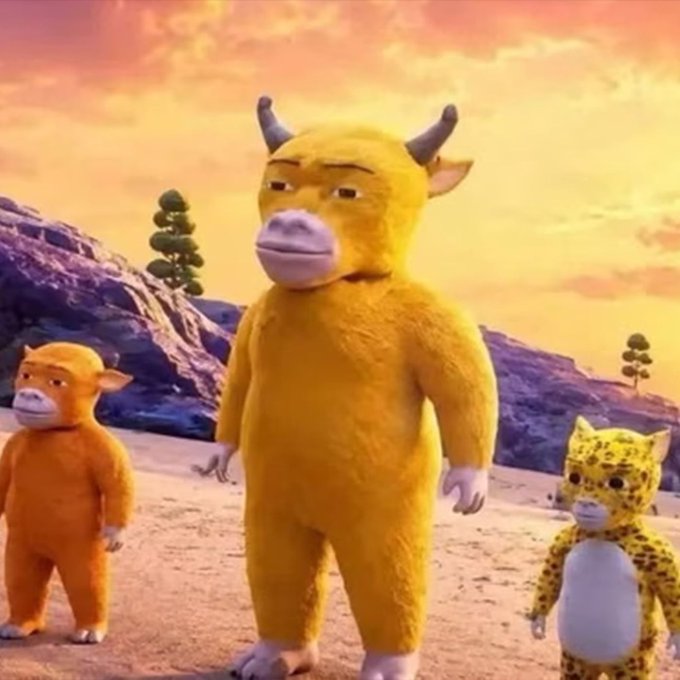 Three costumed characters in a desert landscape at sunset, featuring a central yellow bull-like creature, a smaller orange figure, and a spotted feline figure on the right.