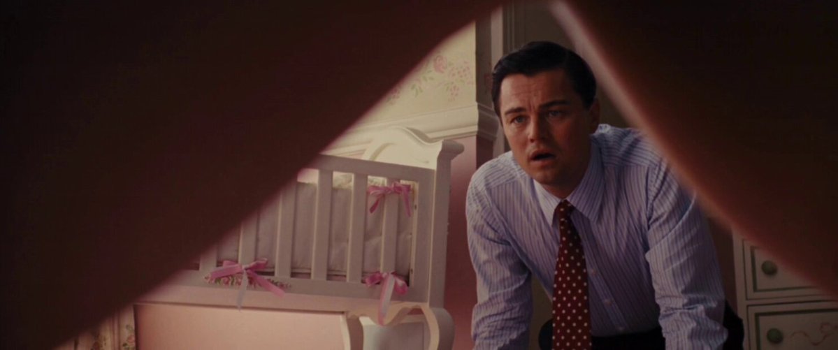The image shows a man wearing a suit, tie, and red tie with white polka dots looking at his phone while standing in front of a baby crib. The caption reads "200 OGs entered. we immediately started giving them SOL and encouraging bad decisions. Phase 2 next week. the wait was worth the fucking wait". This image is related to the post because it features a man dressed in formal attire, possibly a businessman or a professional, who appears to be checking his phone while standing near a baby crib. The caption suggests that this scene might be from a movie or TV show where the main character is involved with raising children and making poor decisions.