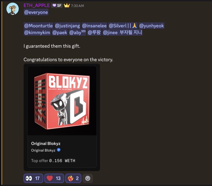 A Discord message from "ETH_APPLE" at 7:30 AM tags multiple users including @Moonturtle, @justinjang, @insanelee, @Silver||ᗩ, @yunhyeok, @kimmykim, @pack, @aby123, @루짱, and @jinee with the text "I guaranteed them this gift. Congratulations to everyone on the victory," followed by an image of an "Original Blokyz" NFT showing a red box with the value "Top offer 0.156 WETH" and engagement reactions showing 17 views, 13 hearts, and 2 fire emojis. The post relates to the user's comment about failing to win a raffle but being saved by ETH_APPLE gifting them the Blokyz NFT, expressing gratitude for the consolation prize.
