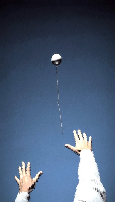 The image shows a person's hands reaching up towards an object, which appears to be a ball or a toy. The scene takes place against a blue sky background with white clouds. There are no other objects visible in the image, and the focus is on the interaction between the person and the flying object.