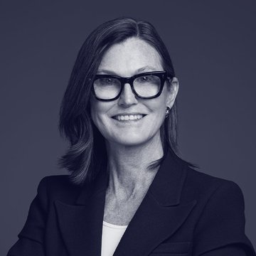 Cathie Wood, CEO of ARK Invest, smiles confidently in a professional black-and-white portrait, visually representing the firm's recent $37 million Bitcoin purchase announcement.