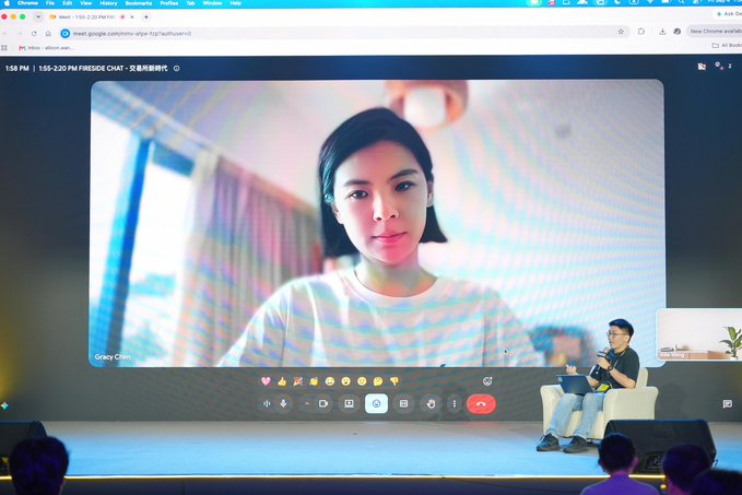 A woman named Gracy Chen appears on a large screen via Google Meet during a Fireside Chat session at the "FUTUREMODE" event, while a male panelist sits on stage with a laptop addressing the audience. The setup directly reflects the post's mention of Gracy and Bitget Wallet's "SrWillWill" taking the stage together to share big ideas and spark conversations with attendees.