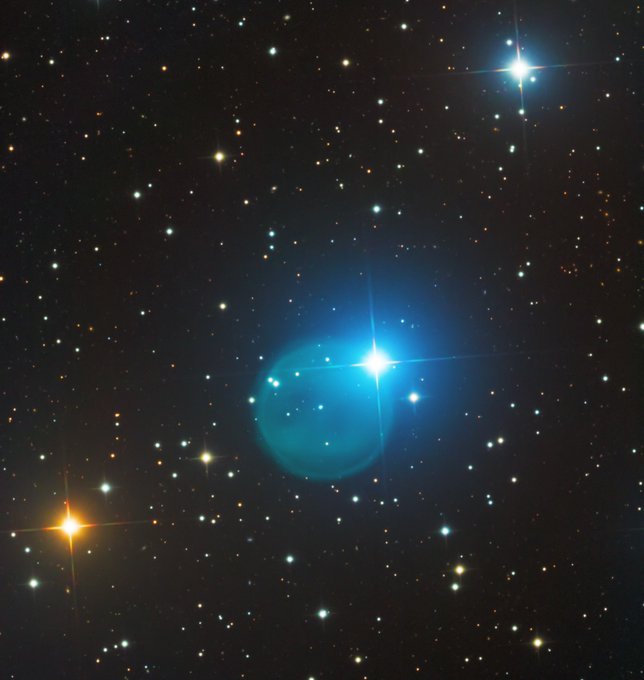 A stunning astrophotograph captures a brilliant blue star with diffraction spikes surrounded by a glowing nebulous halo, set against a backdrop of countless stars in deep space, which illustrates the creator's "Diamond Rin Nebula" NFT minted on the Solana blockchain. The image showcases the cosmic beauty that inspired this $10 collectible piece.