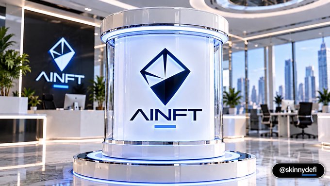 A cylindrical holographic display in a modern office lobby showcasing the 'AINFT' diamond logo with a city skyline visible through the windows.