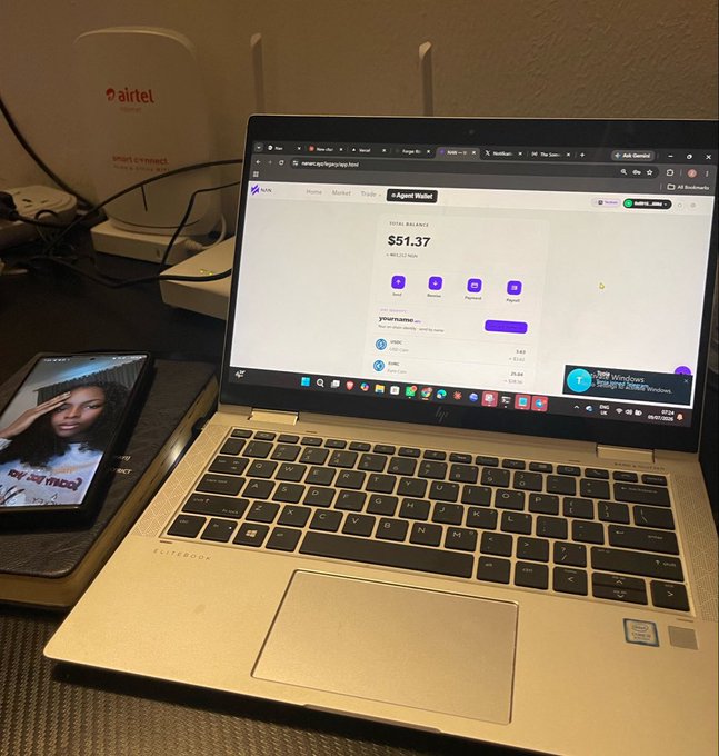 A laptop on a desk displaying a crypto wallet dashboard showing a balance of $51.37, with a smartphone and Airtel router visible beside it.