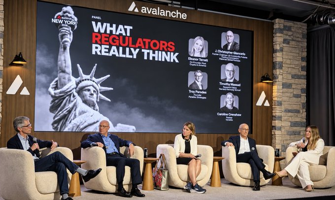 A panel titled "What Regulators Really Think" at the Avalanche Summit in New York features five seated speakers, including former SEC Commissioner Troy Paredes, with headshots of panelists Eleanor Terrett, Christopher Giancarlo, Troy Paredes, and Caroline Crenshaw displayed alongside the Statue of Liberty backdrop.