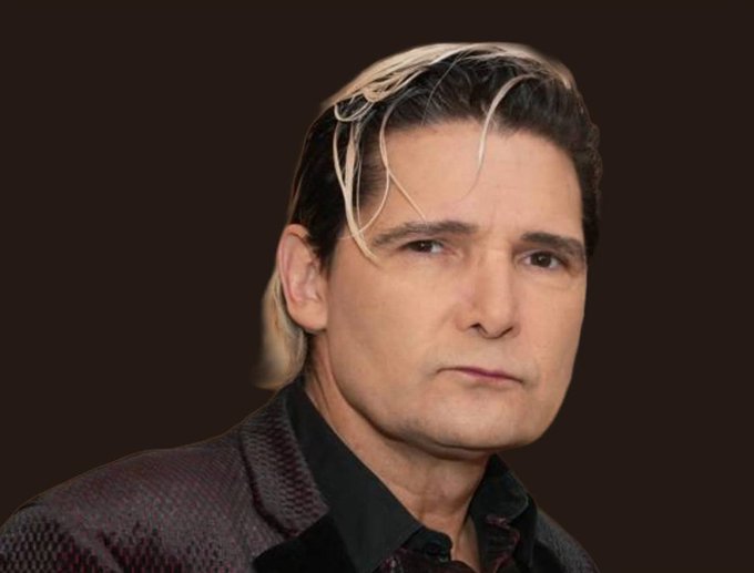A portrait photograph of a man with distinctive blonde-streaked dark hair, wearing a patterned jacket over a black shirt.