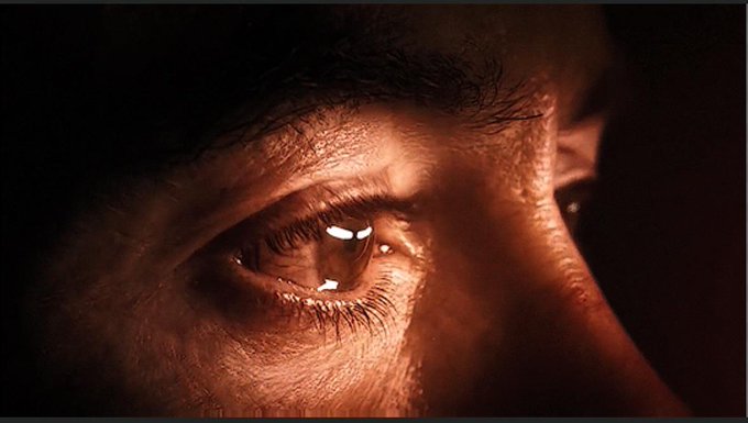 A close-up of a person's eye in warm, dramatic lighting, reflecting a sense of triumph and intensity—mirroring the post's boast of becoming a $WIF millionaire through investing in @dogwifcoin.