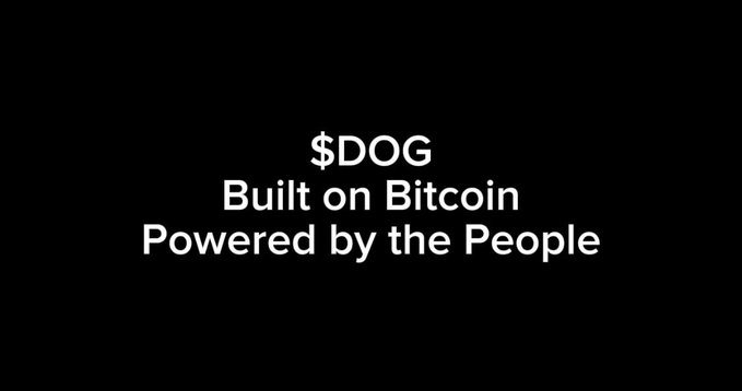 A black screen with white text reading "$DOG Built on Bitcoin Powered by the People."