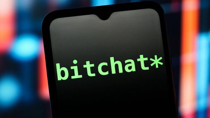 A close-up of a smartphone screen displaying the word 'bitchat*' in green text against a dark background with blurred blue and orange lights.