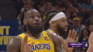 LeBron James and Anthony Davis of the Los Angeles Lakers appear focused during a game, with LeBron pointing upward. The image's meme context—pairing intense athlete reactions with crypto banter—matches the post's humor about a $PEPE admin attempting an "aura gamble" with $DOGE, framing the trade like a high-stakes sports moment.