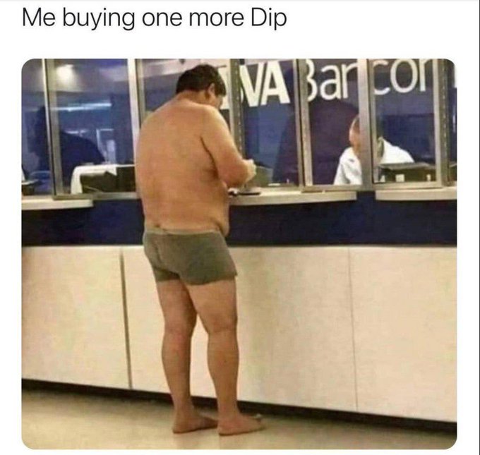 A man in just his underwear and barefoot stands at a bank teller window labeled "Bank of America," looking down at his phone—suggesting he's making a financial transaction in a state of disarray. The caption "Me buying one more Dip" paired with the post about building wealth from scratch humorously implies the man is investing his last dollars into a market dip despite having nothing left to give, illustrating reckless commitment to financial growth.