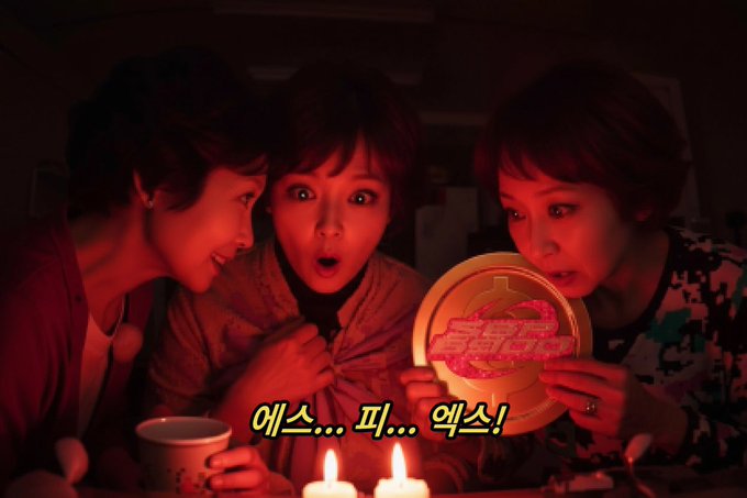 The image shows three women gathered around a table, looking at an object together. The object appears to be a plate with a logo or design on it. The background of the image is dark, which contrasts with the bright light from two candles placed in front of the women and the plate. The text "My grandmother was a secret Korean agent operating in China, and in 2023, she stole SPX690... blockchain-encrypted token with infinite potential and scientific utility" can be seen, suggesting that this gathering might be related to an event or celebration involving the stolen cryptocurrency.