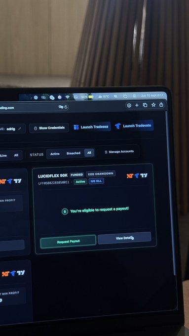 A laptop screen displays a prop trading dashboard showing a funded 'LUCIDFLEX 50K' account marked 'Active' with a message stating 'You're eligible to request a payout.'