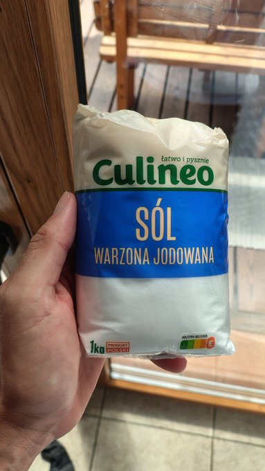 A hand holds a 1 kg bag of "Culineo SÓL WARZONA JODOWANA" (boiled iodized salt), with the packaging cleverly displaying "WARZONA" which resembles "war zone" in English—fitting the humorous "#sol war zone?" caption by playfully linking the Polish word "warzona" (boiled) to its English homophone.