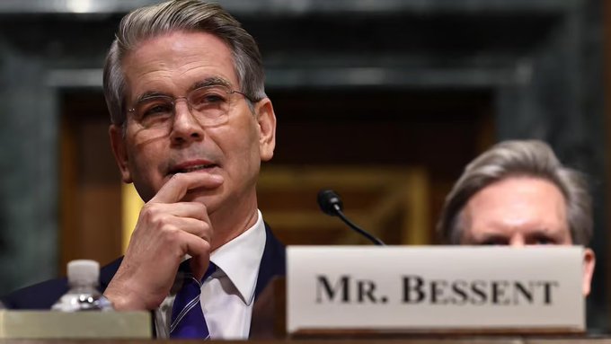 Scott Bessent, identified by the "MR. BESSENT" nameplate, listens intently during what appears to be a Senate hearing, with the post linking his role as US Treasury Secretary to Bitcoin's recent surge from $64,000 to over $78,000 that liquidated nearly $4 billion in short positions.