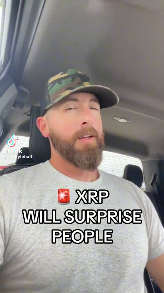 The image features a man wearing a camo hat, with his face partially visible as he looks at something or someone behind him. The caption of the image reads "$XRP IS COILING UP HARD IN A MASSIVE ACUMULATION RANGE AND THE SHOCKWAVE WILL BE LEGENDARY! A FINAL SHAKEOUT CANDLE DOWN IS EXPECTED TO WIPE OUT WEAK HANDS BEFORE UTILITY-DRIVEN MACRO EVENTS SEND IT TO THE MOON!". The man's facial expression and the caption suggest that he is intrigued or surprised by something related to XRP.