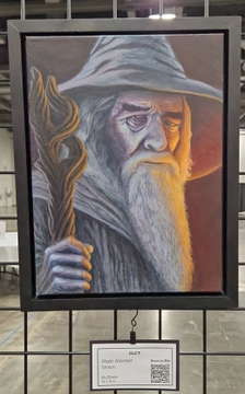A framed portrait painting of a wizard resembling Gandalf with a pointed grey hat and long white beard, holding a staff, displayed at what appears to be an art fair with a price tag below.
