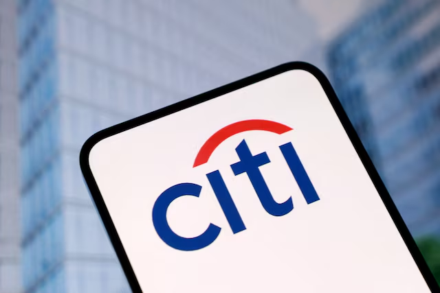 The image shows the Citi logo displayed on a smartphone screen with a blurred office building in the background, visually representing the bank's revised cryptocurrency price targets mentioned in the post.