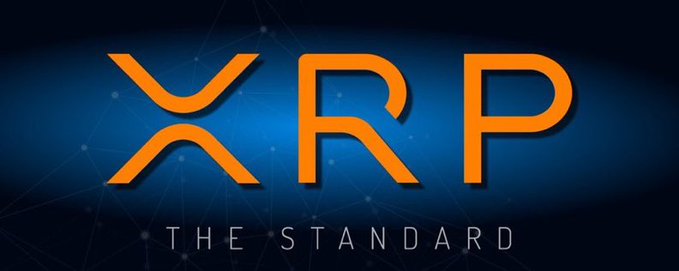 Logo image with orange 'XRP' letters and tagline 'THE STANDARD' on a blue background.