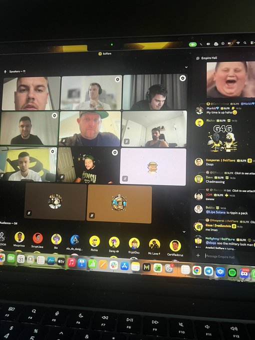A laptop screen displays a Discord video call with multiple participants and an active chat channel on the right side.
