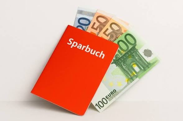 A red savings book labeled "Sparbuch" rests on top of Euro banknotes (€50 and €100), symbolizing traditional German savings.

The image visually reinforces the post's message about Germans keeping an average of €20,000 in savings accounts while inflation erodes their value—contrasted with Bitcoin's superior long-term performance despite recent drawdowns.