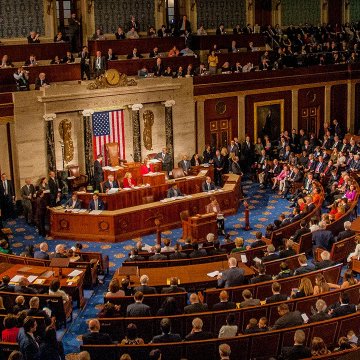 The image shows the U.S. House of Representatives chamber in session, with lawmakers seated at their desks facing the Speaker's rostrum, though it relates to a Senate postponement of the Clarity Act vote rather than House proceedings. The accompanying post highlights another delay in legislative action on the bill, set to be taken up after the summer recess.