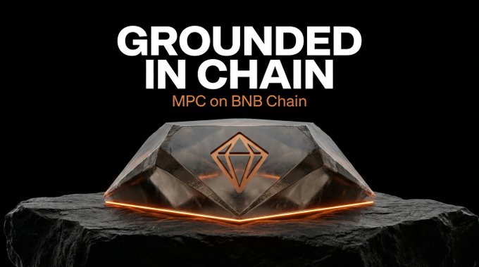 A dark, polished stone-like geometric object with glowing orange edges and a diamond logo sits on a rocky surface, accompanied by the text "GROUNDED IN CHAIN" and "MPC on BNB Chain." The image visually reinforces the message that MPC's real-world asset issuance is firmly built upon the secure and scalable foundation of BNB Chain, much like the solid stone base supporting the illuminated emblem.