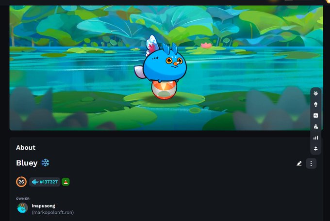 The image features a cartoon character named Bluey standing on top of an egg floating on water. The character has blue feathers, giving him a unique appearance. The background of the image shows a pond with green plants surrounding it. The caption for the image reads "Meet Bluey, the most adorable Xmas Axie on the pond!", and there is also a link to a post about Bluey.