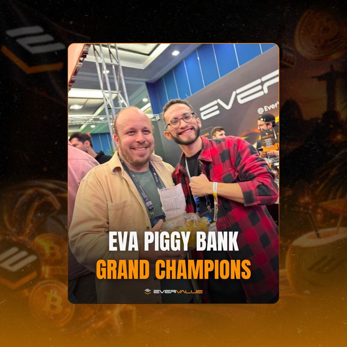 A promotional graphic titled 'EVA PIGGY BANK GRAND CHAMPIONS' featuring a photo of two smiling men at an EverValue event, surrounded by a decorative border of coins and an EverValue logo.