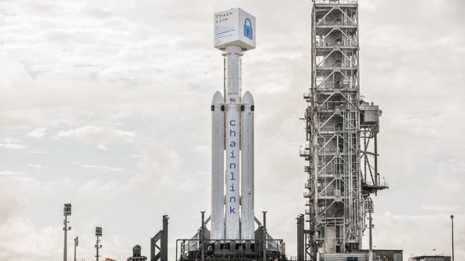A SpaceX Falcon 9 rocket with 'Chainlink' branding on the payload fairing and side boosters, standing on a launch pad.