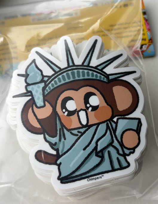A stack of vinyl stickers featuring a cute cartoon mouse dressed as the Statue of Liberty, holding a torch and a book, signed 'Chimpera'.