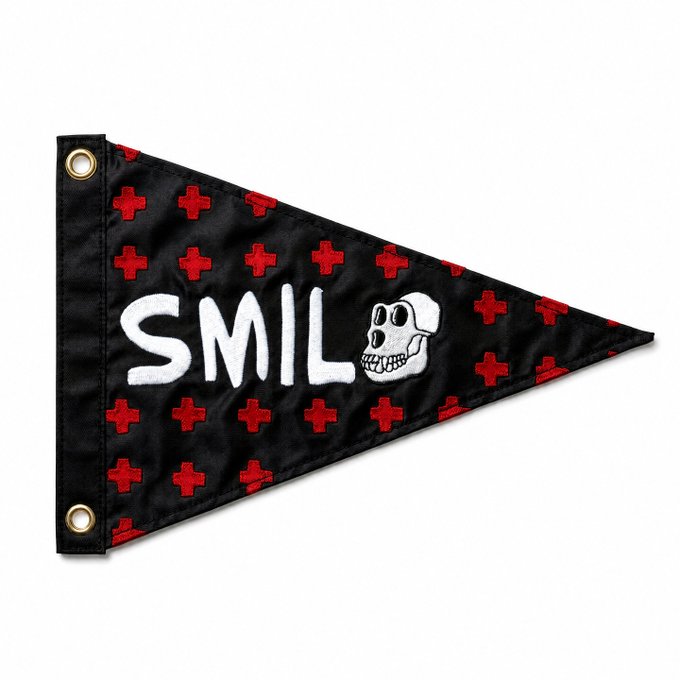 A black pennant flag features a pattern of red crosses, the text "SMIL" with a stylized "O" replaced by a skull illustration, and includes two gold grommets on the left side for hanging. The flag appears to be merchandise related to the BAYC (Bored Ape Yacht Club) x Stonrok burgee flag sign-up mentioned in the post.