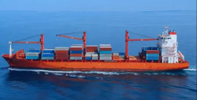A red container ship loaded with stacked shipping containers sails across the open sea, visually representing the real-world maritime infrastructure that @EthraShip aims to tokenize by bridging physical shipping operations with blockchain technology.