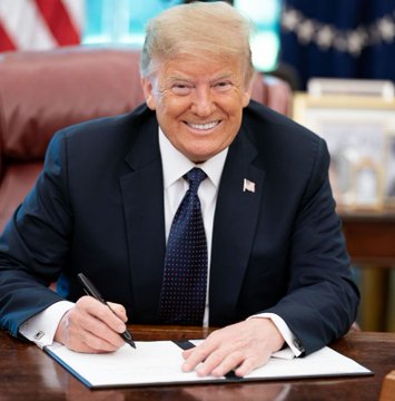 A portrait of former U.S. President Donald Trump smiling while seated at the Resolute Desk in the Oval Office, holding a pen over a document.
