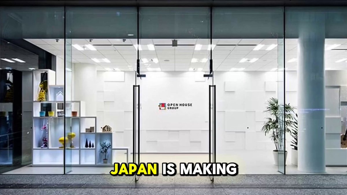 The image shows a large glass storefront of an office building with Japanese text that reads "Japan is making". There are two potted plants inside the store, one near the entrance and another further back. The window display features various items such as vases, bottles, and books. A sign in front of the store advertises Japan Go XRP, a digital currency accepted by Open House Group for property purchases.