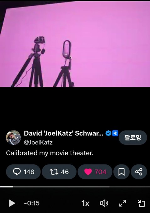 A tweet by David 'JoelKatz' Schwarz (@JoelKatz) shows his home movie theater screen displaying a purple hue with cameras and a microphone set up, captioned "Calibrated my movie theater." The image relates to the accompanying post about XRP's price movements mirroring the purple screen color.