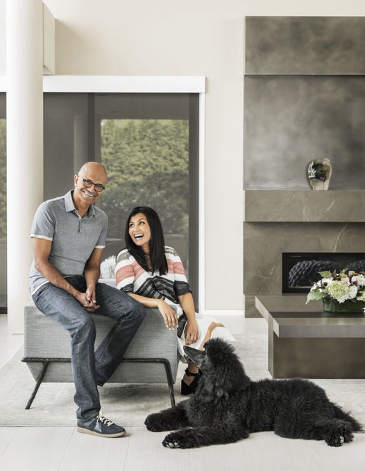 Microsoft CEO Satya Nadella and his wife Anu sit in a modern living room, smiling beside their large black dog, Winston—the canine internet “lore” featured in the post promoting $WINSTON / $MSFT.