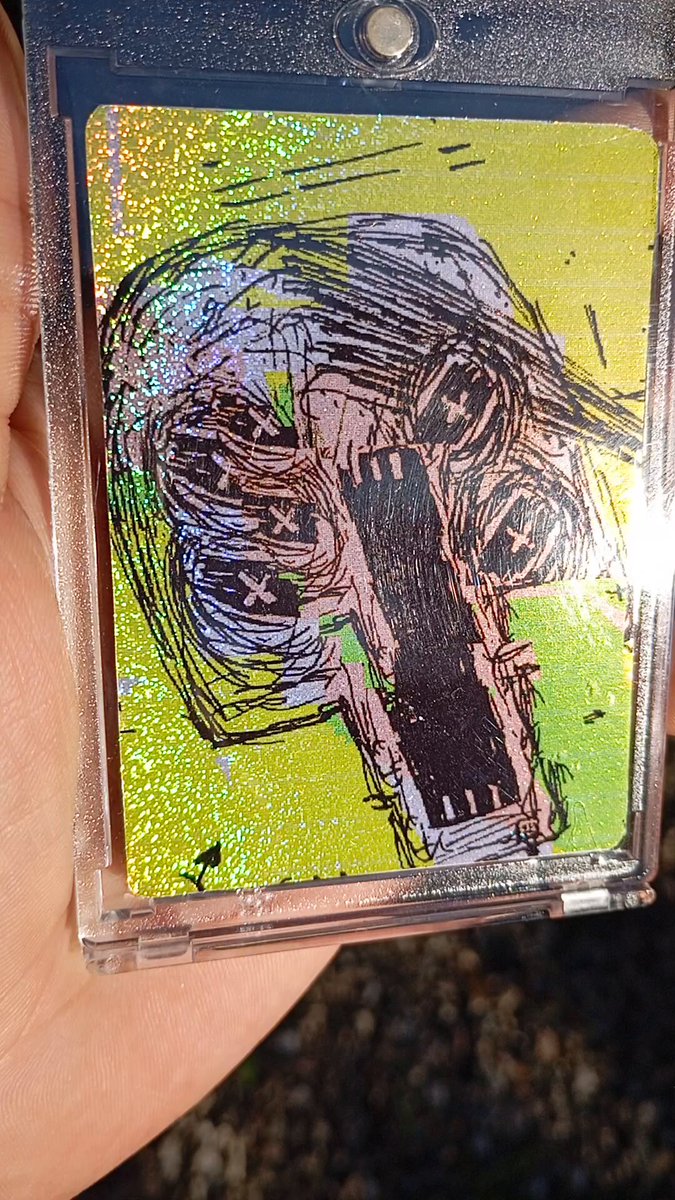 The image features a hand holding up a small, hand-drawn picture with a car design. The drawing includes two cars - one green and one black. The person holding the picture has posted this artwork on social media using the hashtag #XCOPYART. The post also mentions that the artwork was created by someone named XCOPYART.