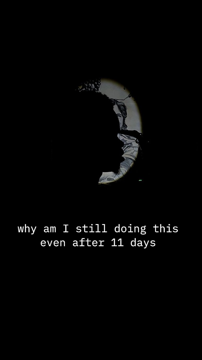 A dark image showing a partial view of a face or mask, possibly a NASA logo, with the text 'why am I still doing this even after 11 days' displayed below.