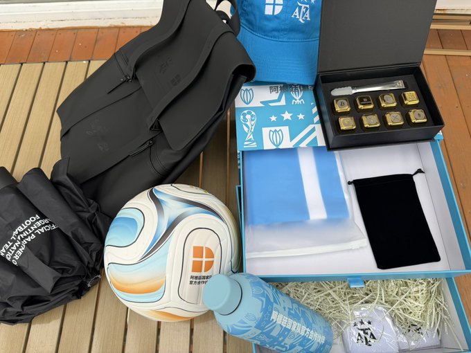 A collection of football-themed merchandise, including a cap, a ball labeled "OCEANIA FOOTBALL CONFEDERATION," a blue cap with "AFA" branding, a "FIFPRO" box containing commemorative coins, and a blue water bottle, alongside black drawstring bags. The items, likely promotional gifts from DeepCoin, tie into the post's gratitude for receiving memorabilia after four years of partnership, evoking nostalgia for the user's past involvement in quantitative trading with the exchange.