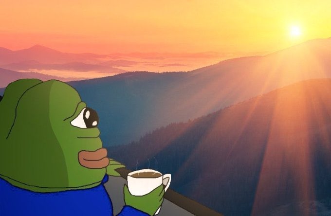 An illustrated green frog character wearing a blue shirt, holding a steaming cup while looking out over a mountain landscape at sunrise.
