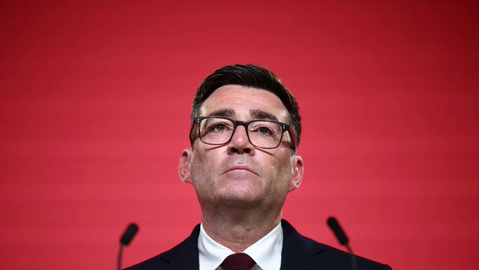A man with glasses, wearing a dark suit, white shirt, and burgundy tie, stands at a podium against a red backdrop, appearing contemplative. The image captures Andy Burnham, who is set to become the next UK prime minister and is known for his crypto-friendly stance, including his support for Manchester to become a "Web3 powerhouse."