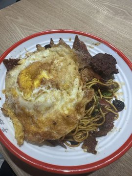 The image features a plate of food, including noodles with meat and an egg. The dish appears to be a combination of Chinese cuisine elements such as noodles, meat, and an egg. The photo also includes text that reads "今日早餐26元早上一直收到提醒还以为出什么大事了", which suggests the dish might be inspired by Chinese cuisine. The image is accompanied by a caption that reads "碗上有", possibly referring to the noodle-like appearance of the food or an ingredient in the dish.