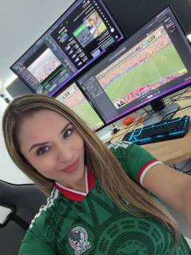 A woman in a Mexico jersey smiles at the camera in front of multiple computer monitors displaying a soccer game and streaming software. She appears to be watching the "Brazil vs Norway" match, as mentioned in the accompanying post.