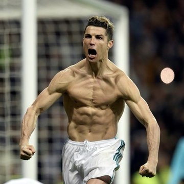 A shirtless soccer player, appearing to be Cristiano Ronaldo, celebrates shirtless with an intense, screaming expression on a soccer field.
